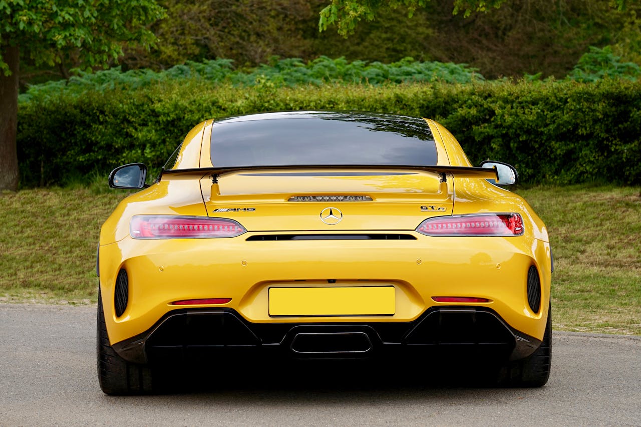 about-04 Yellow sports car parked outdoors, showcasing sleek design and vibrant color.